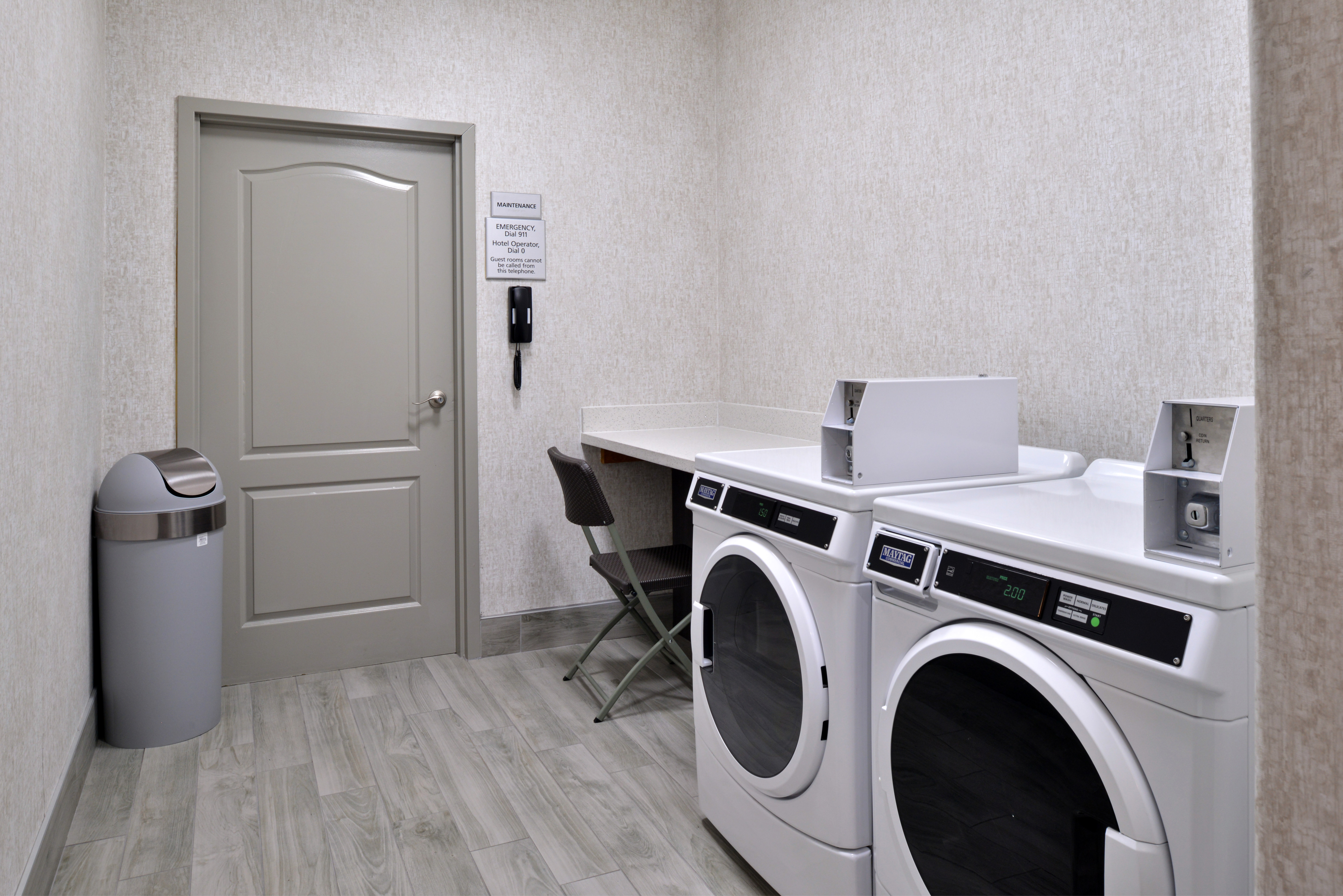 Laundry room with machines, table and chair