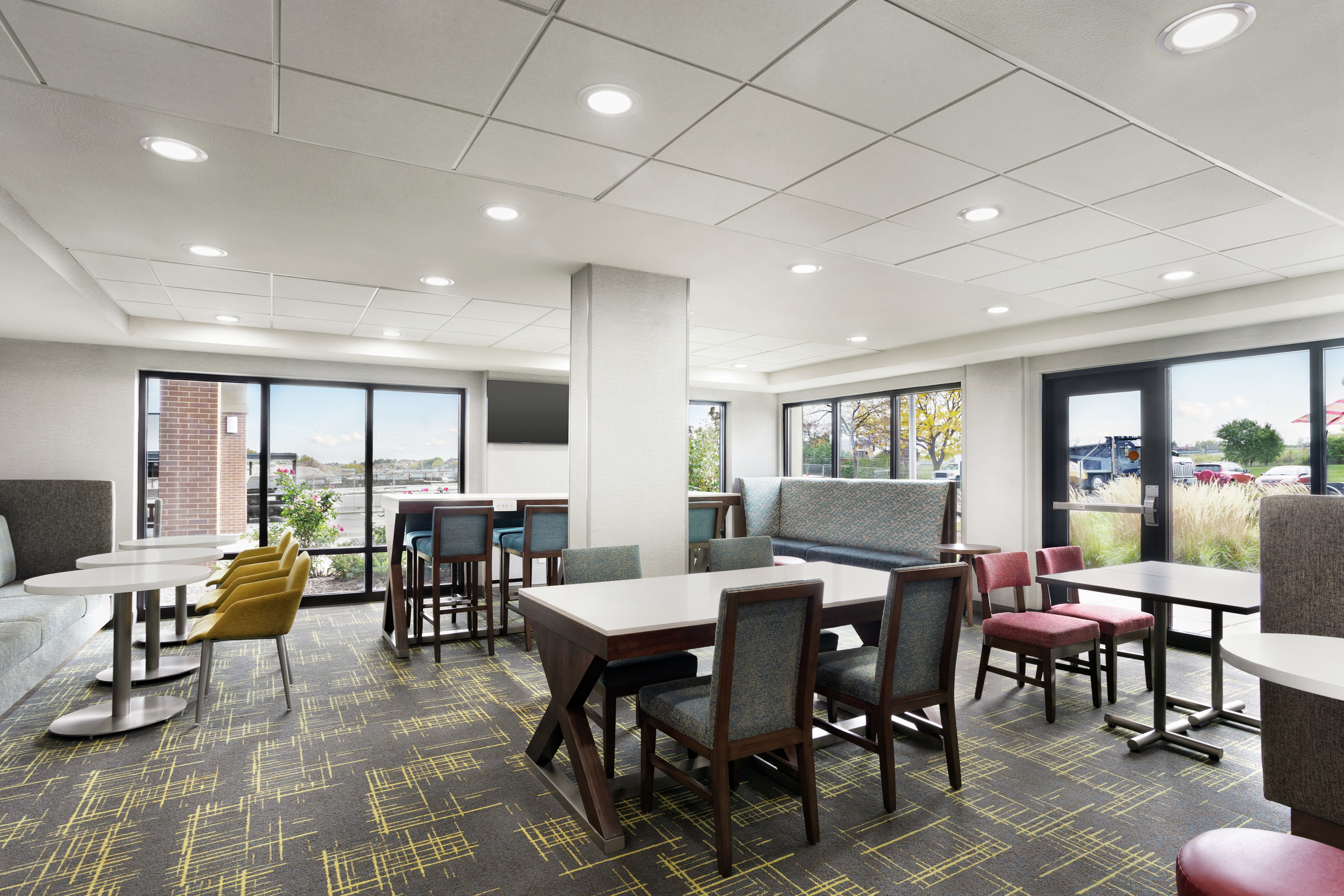 Spacious hotel lobby featuring ample seating and large windows with natural light.