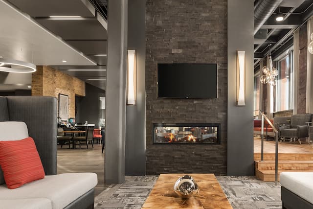 Lobby Lounge with Couches, Coffee Table, Wall Mounted TV and Fireplace