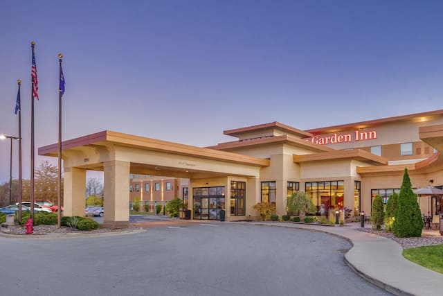 View of Hotel Exterior, Lanscaping, and Porte-Cochère at Dusk