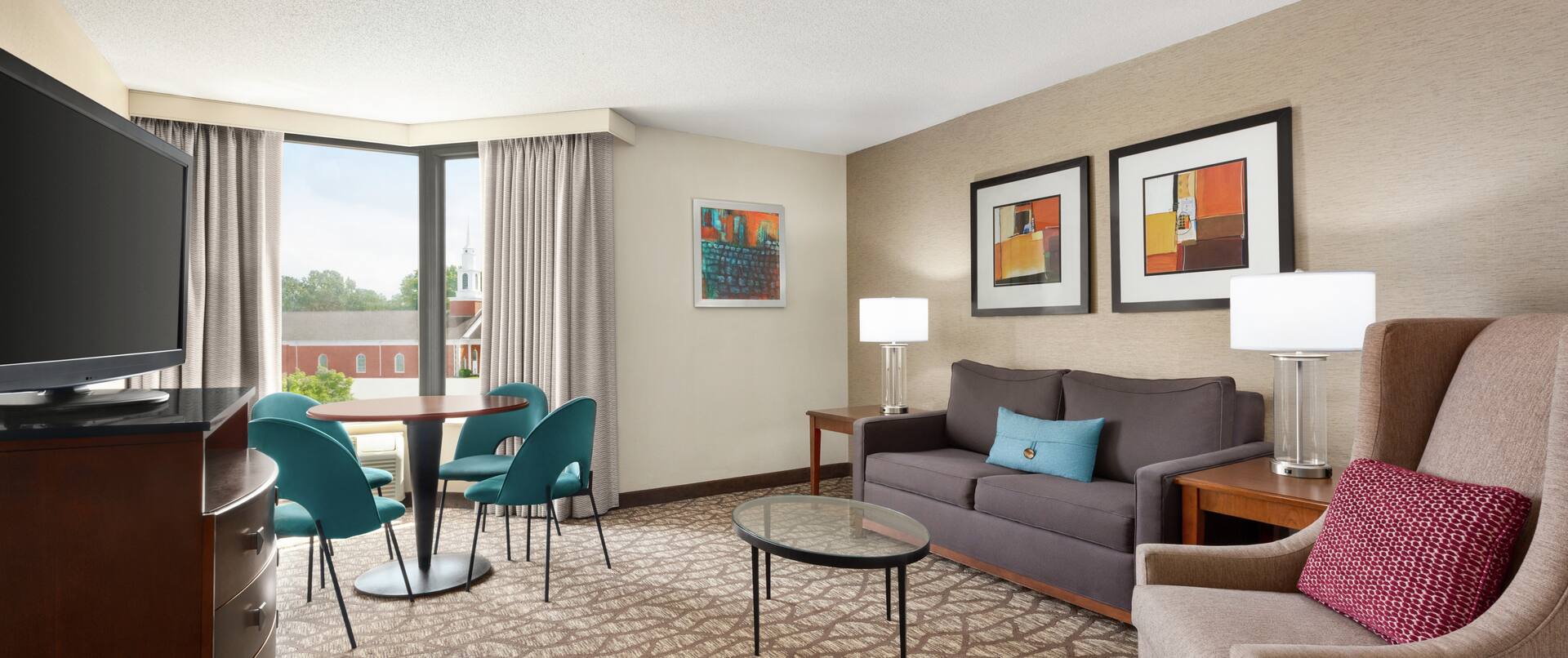 Spacious living area in parlour suite featuring comfortable seating, TV, and dining table.