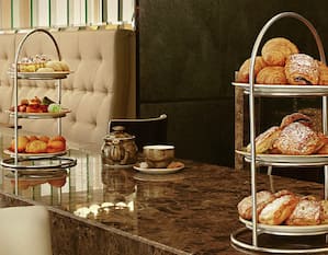 Pastries and Teapots on Counter at Axis Lounge With Seating For High Tea