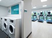 Laundry Room and Partial View of Treadmills in Fitness Center