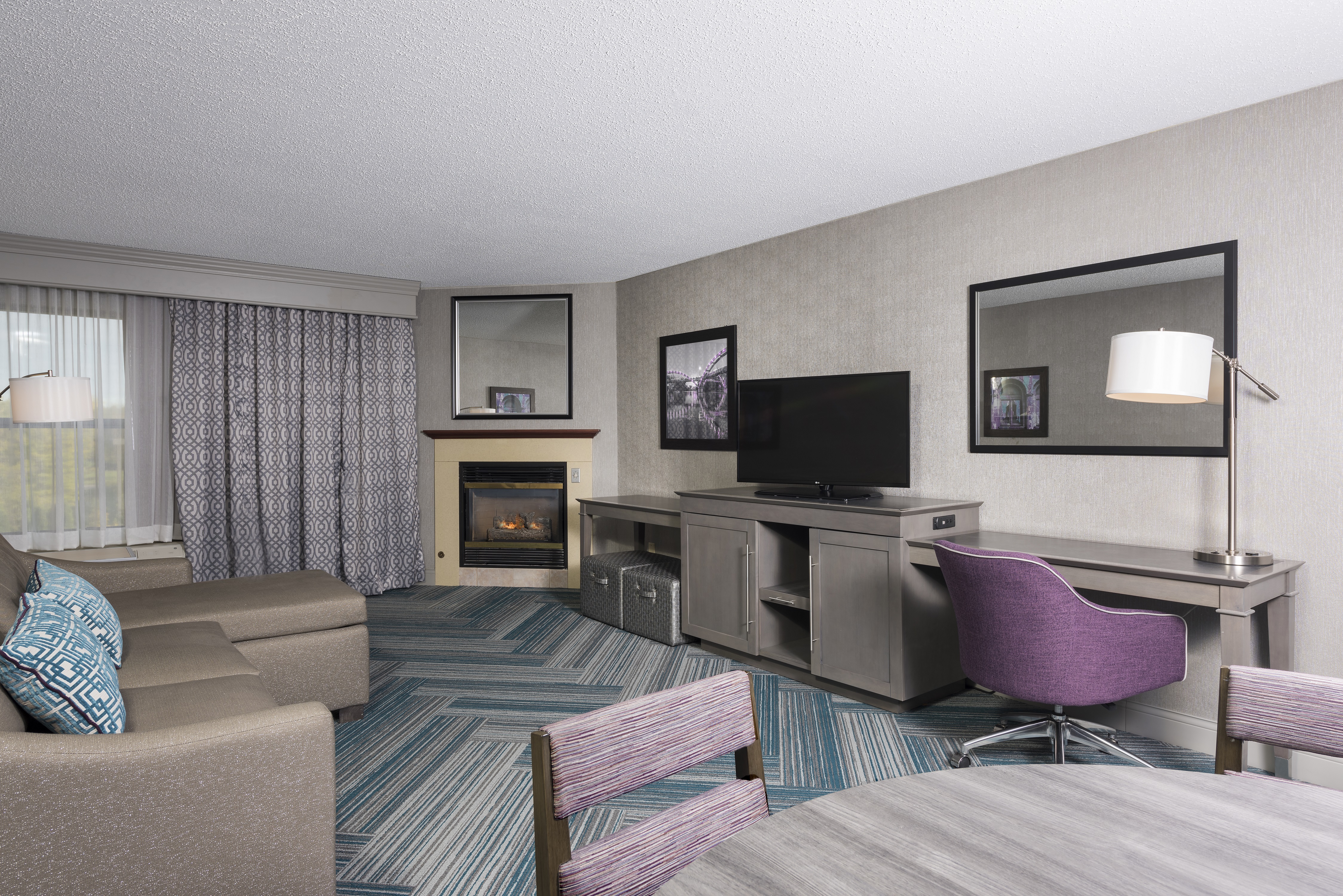 Guest Suite Lounge Area with HDTV, Work Desk, Fireplace and Sofa