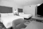 Guest room with two beds, a work desk, and TV.
