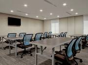 Classroom Setup in Meeting Room With Tables and Chairs Facing TV