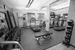 Fitness Center With Weight Machine, Cardio Equipment, TV, Bench, Weight Balls, Free Weights, and Large Mirrors
