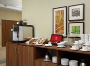 Coffee Maker, Cups, Pastries, and Sweeteners on Counter of Breakfast Area