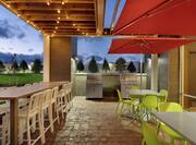 Beautiful outdoor patio area featuring ample seating, BBQ Grills, and string lights.
