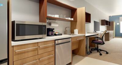 Spacious accessible studio suite featuring fully equipped kitchen, work desk, and TV.