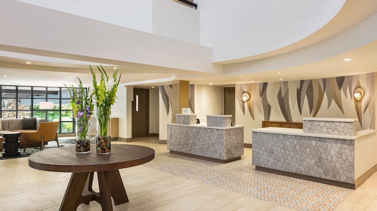 Bright hotel lobby featuring an accommodating front desk