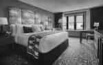 king sized bed in guest room with large windows