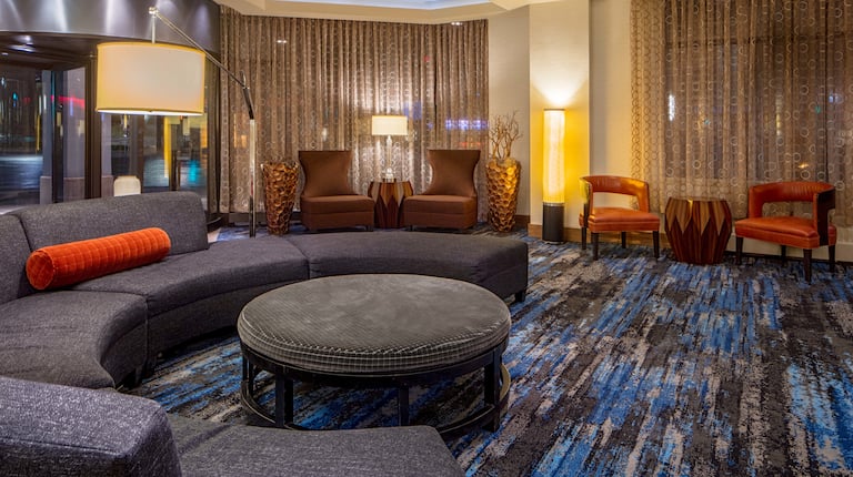 Lobby seating area with curved sofa, ottoman, and soft chairs
