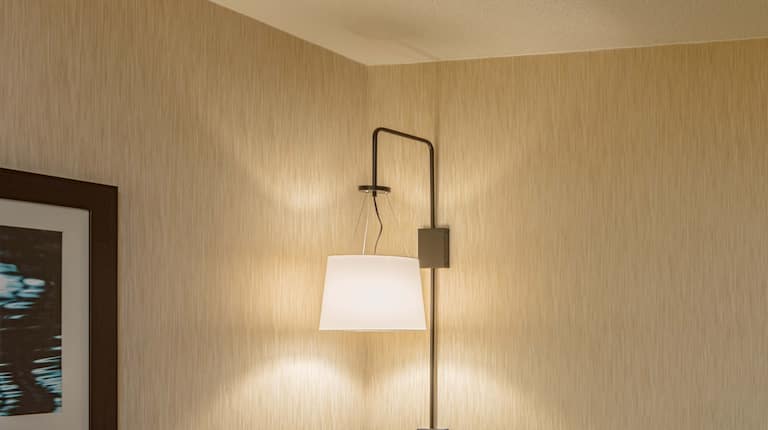 King suite living area with L-shaped sofa, ottoman, work desk, and partial view of bedroom