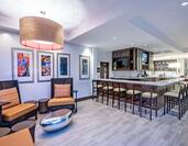 Armchairs, Table, Wall Art, TVs and Counter Seating at Well-Stocked Garden Grille & Bar