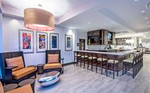 Armchairs, Table, Wall Art, TVs and Counter Seating at Well-Stocked Garden Grille & Bar