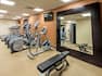 Fitness Center With TV, Cardio Equipment, Large Mirror, and Weight Bench