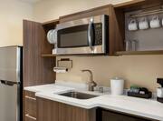 Spacious in-suite kitchen fully equipped with full size fridge, microwave, sink, and coffee maker.