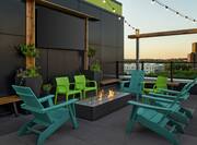 Spacious outdoor rooftop bar featuring firepit and stunning city view.