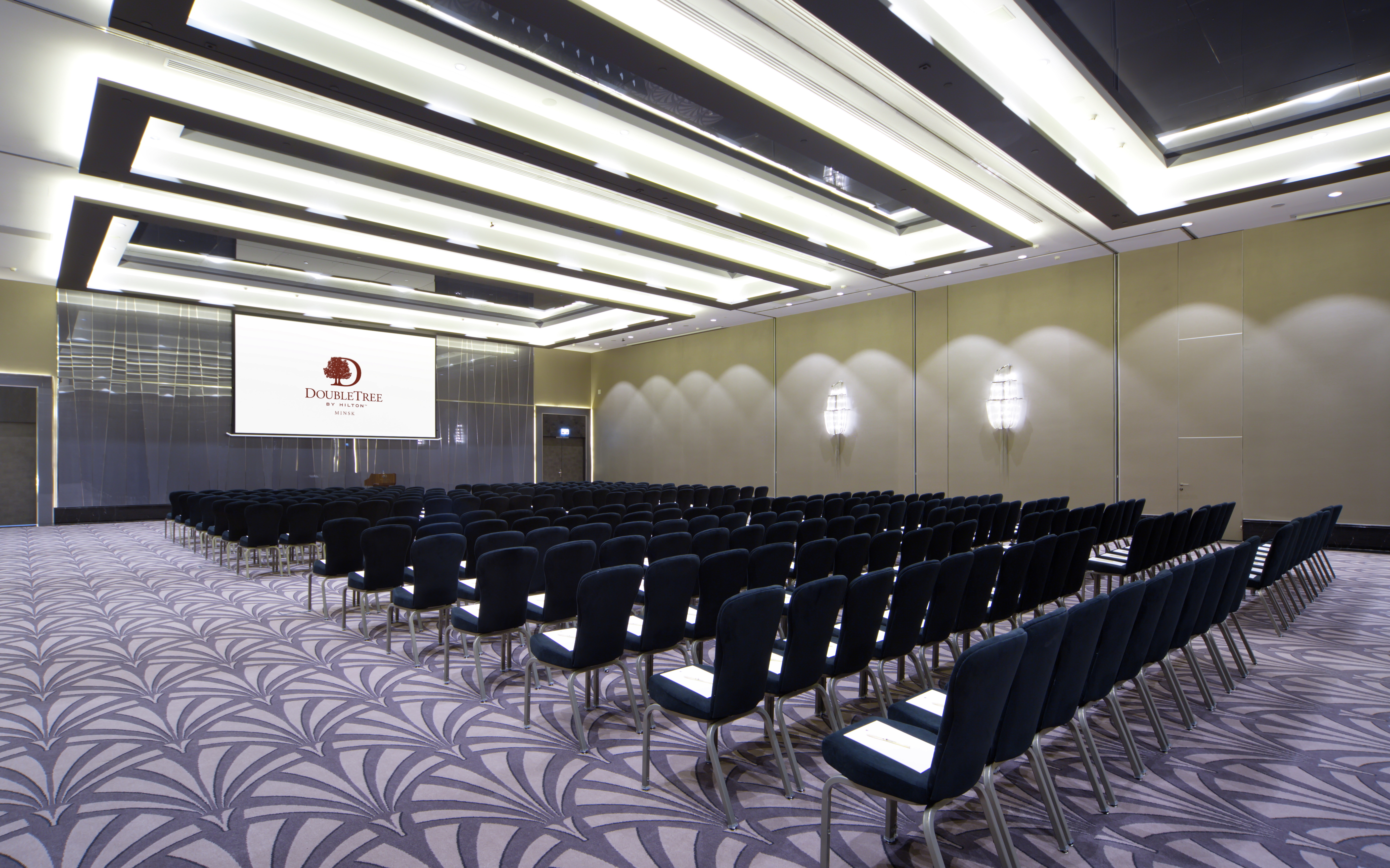 a ballroom and conference space with seating and a presentation screen