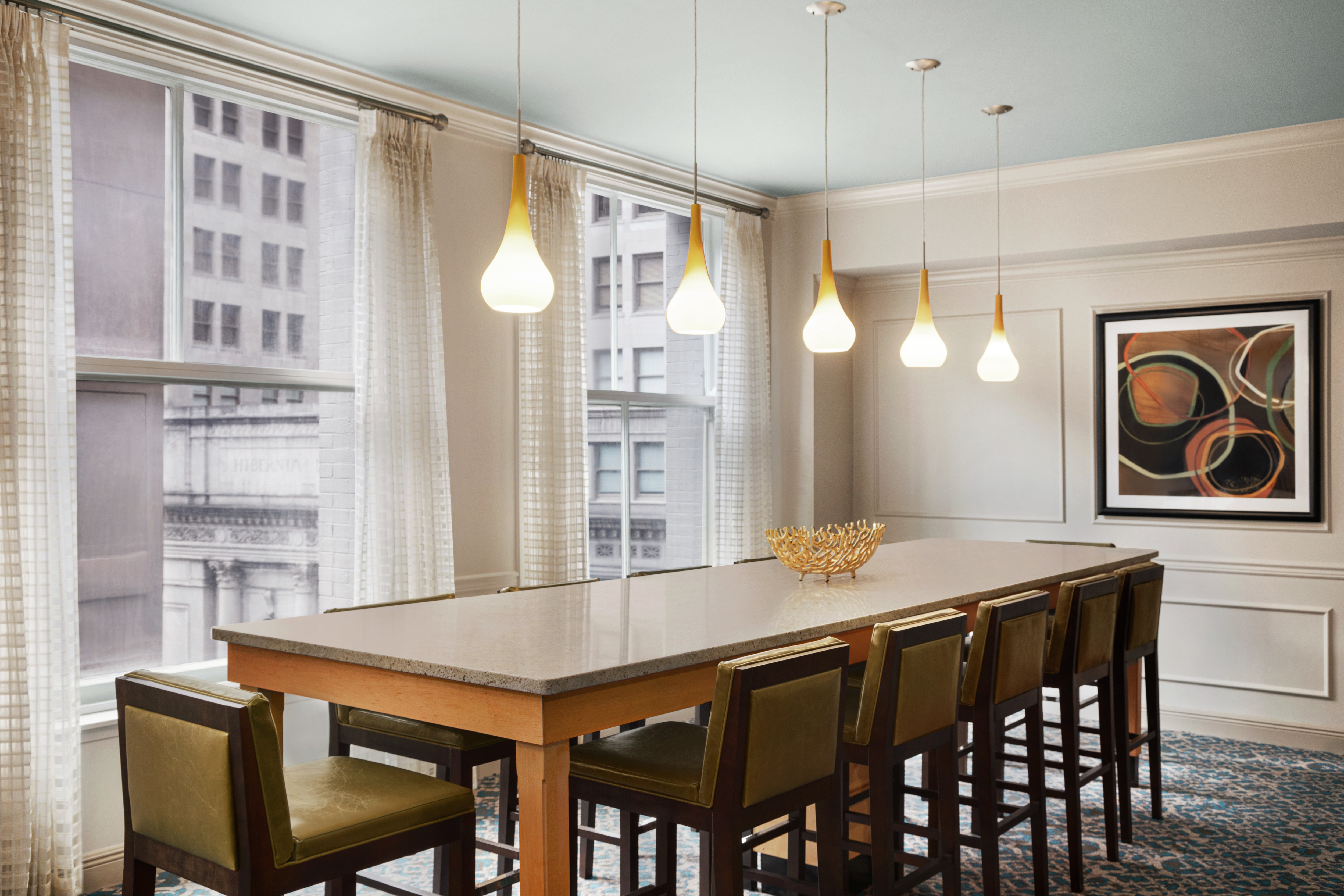 Bright breakfast area featuring large communal table, stylish design, and stunning city view.