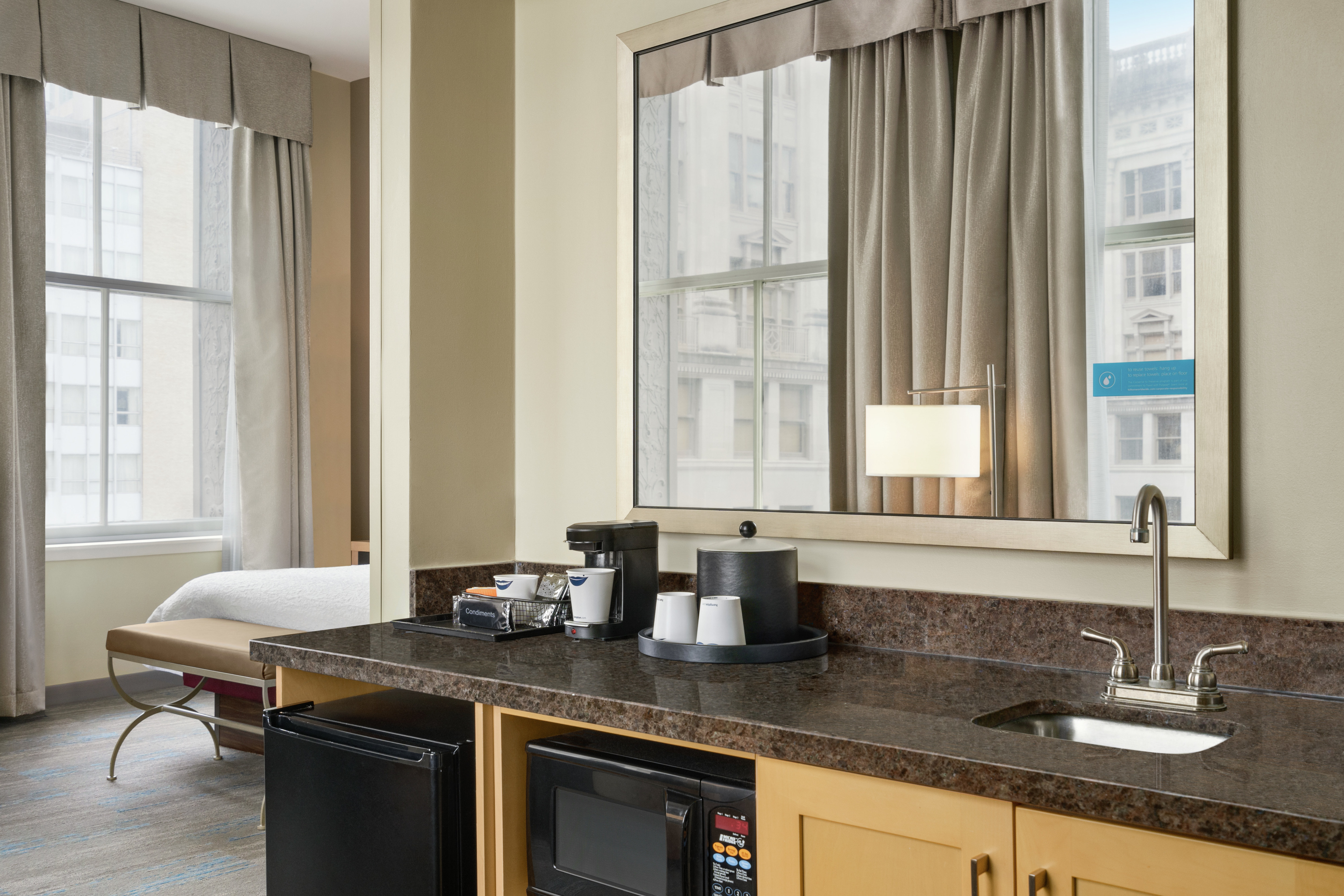 Convenient in-room wet bar featuring sink, mini-refrigerator, and microwave.