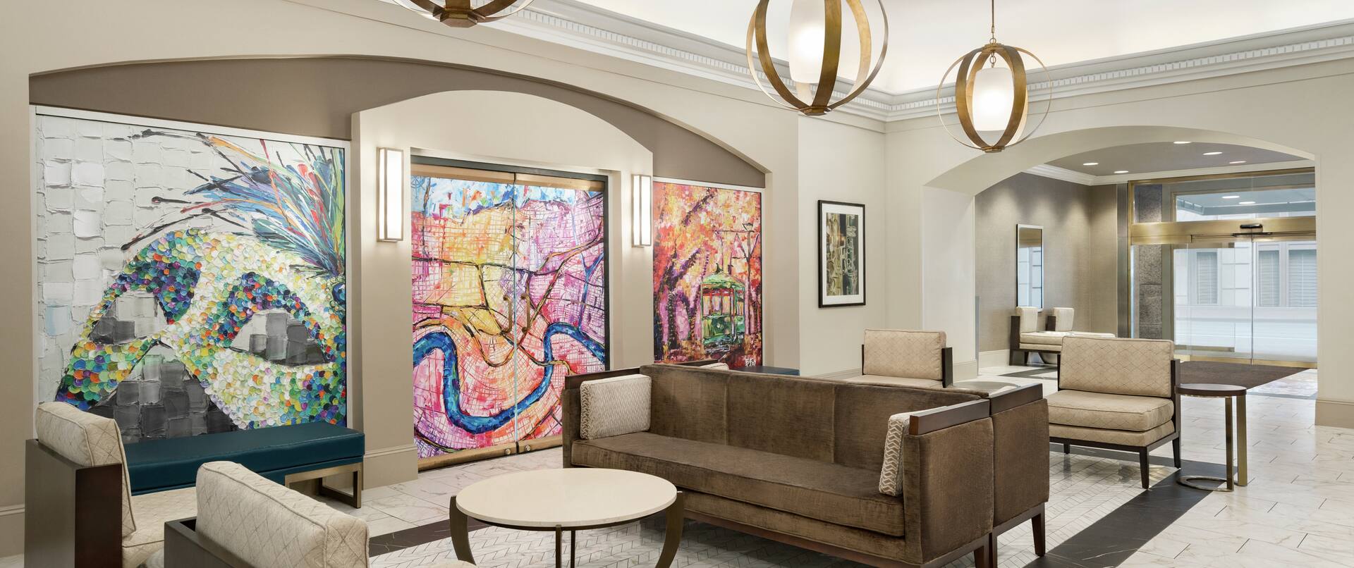 Spacious hotel lobby featuring stylish design, eye-catching mural, and comfortable seating.