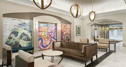 Spacious hotel lobby featuring stylish design, eye-catching mural, and comfortable seating.