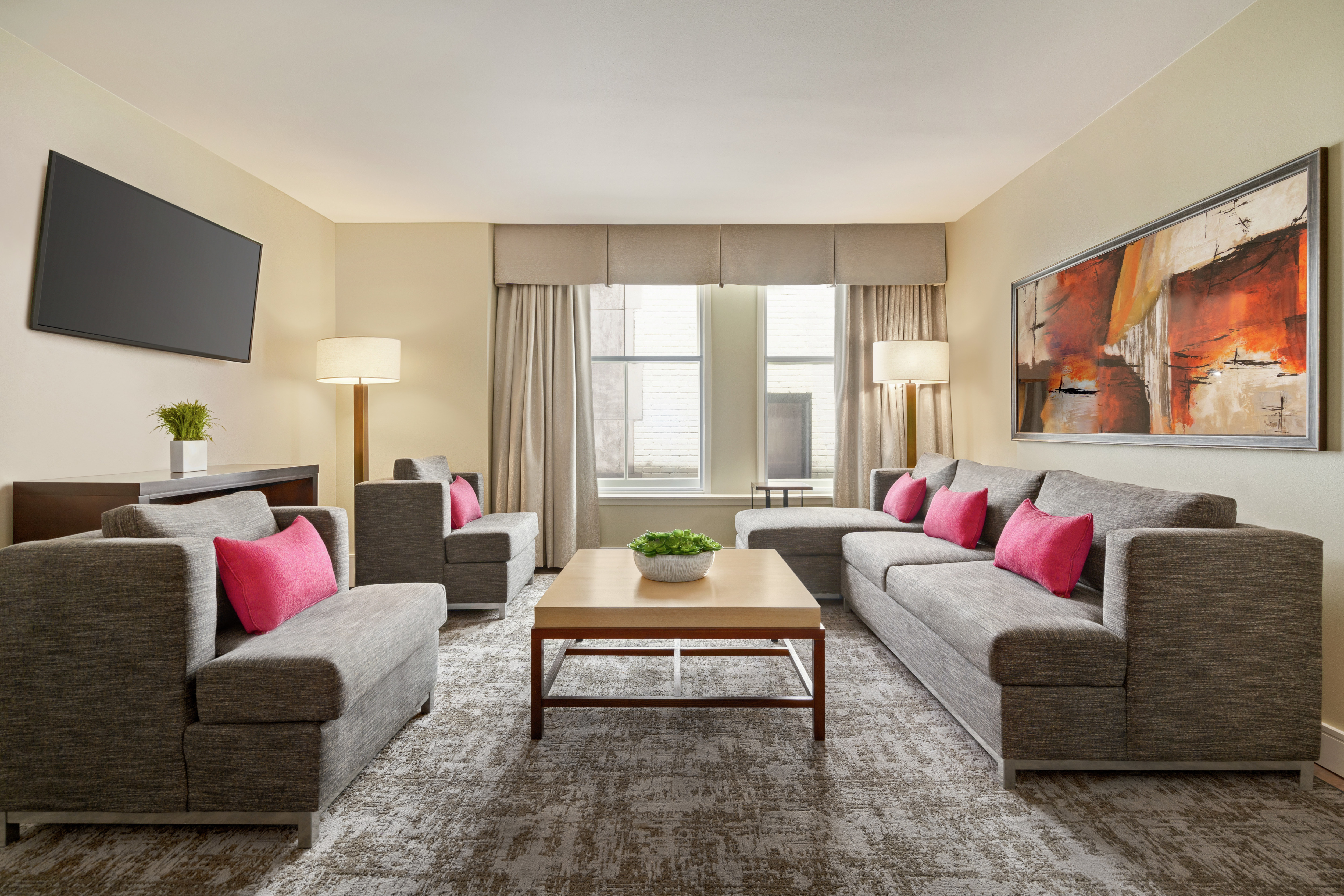 Bright living area in suite featuring comfortable seating, TV, and beautiful outdoor view.