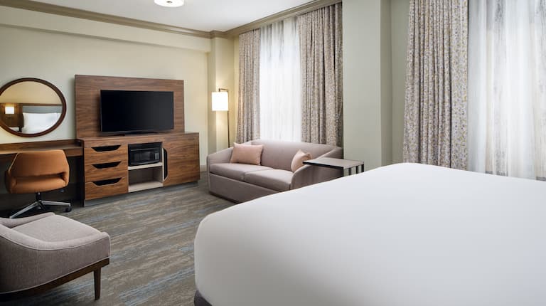 Bed in room with TV and comfortable seating
