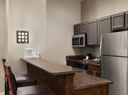 Spacious suite featuring fully equipped kitchen with eat-in breakfast bar.