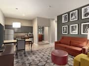 Spacious living area in accessible suite featuring sofa, TV, dining table, and fully equipped kitchen.