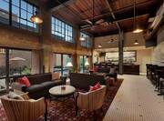 Stunning on-site hotel bar featuring historical design, ample seating, and large windows.