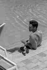 Man Having a Drink while Seating at the Pool Outdoors
