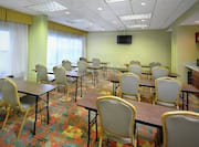 Windows With Sheer Drapes in Classroom Style Meeting Room With Tables and Chairs Facing TV