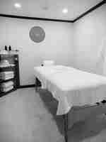 작은 객실의 스파 트리트먼트 침대. 코너에 타월이 있는 선반