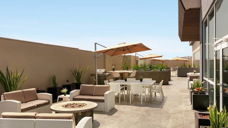 Outdoor Patio Area with Armchairs, Tables and Umbrellas at Daytime