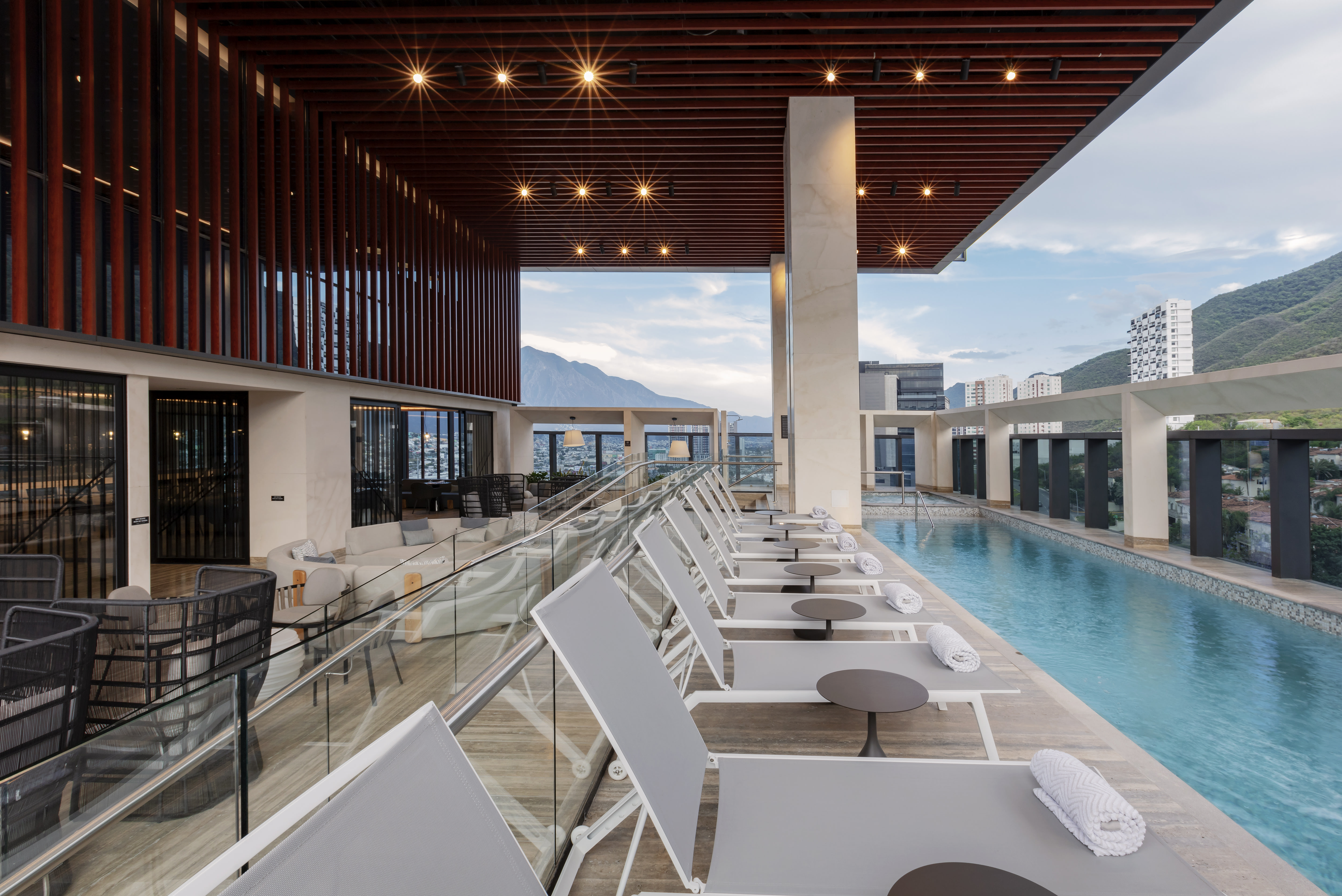 Rooftop pool area with lounge chairs and outdoor bar