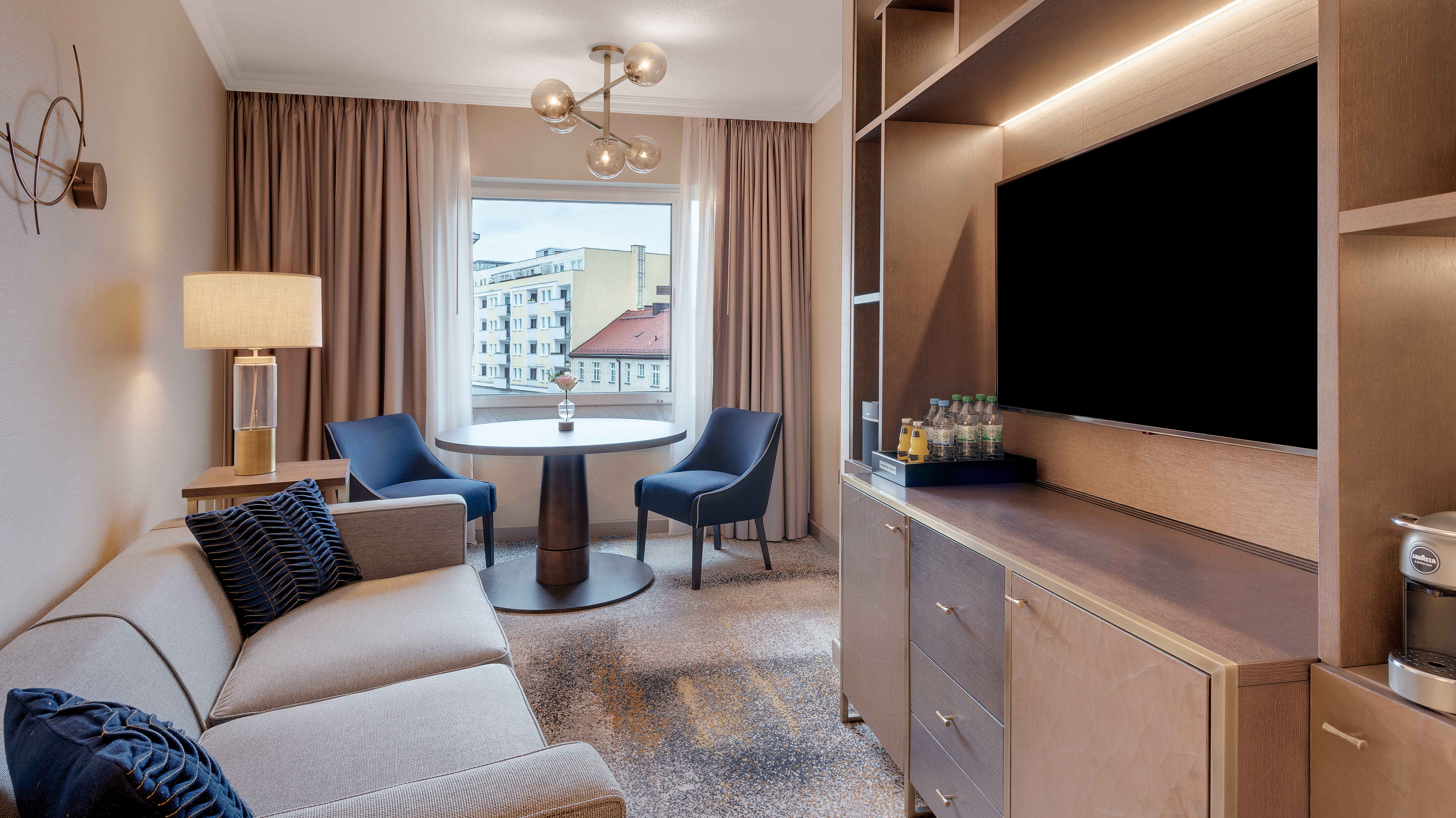 Suite Junior con letti separati - Zona soggiorno, TV, tavolo da pranzo e sedie, finestra Plus con vista sull'esterno