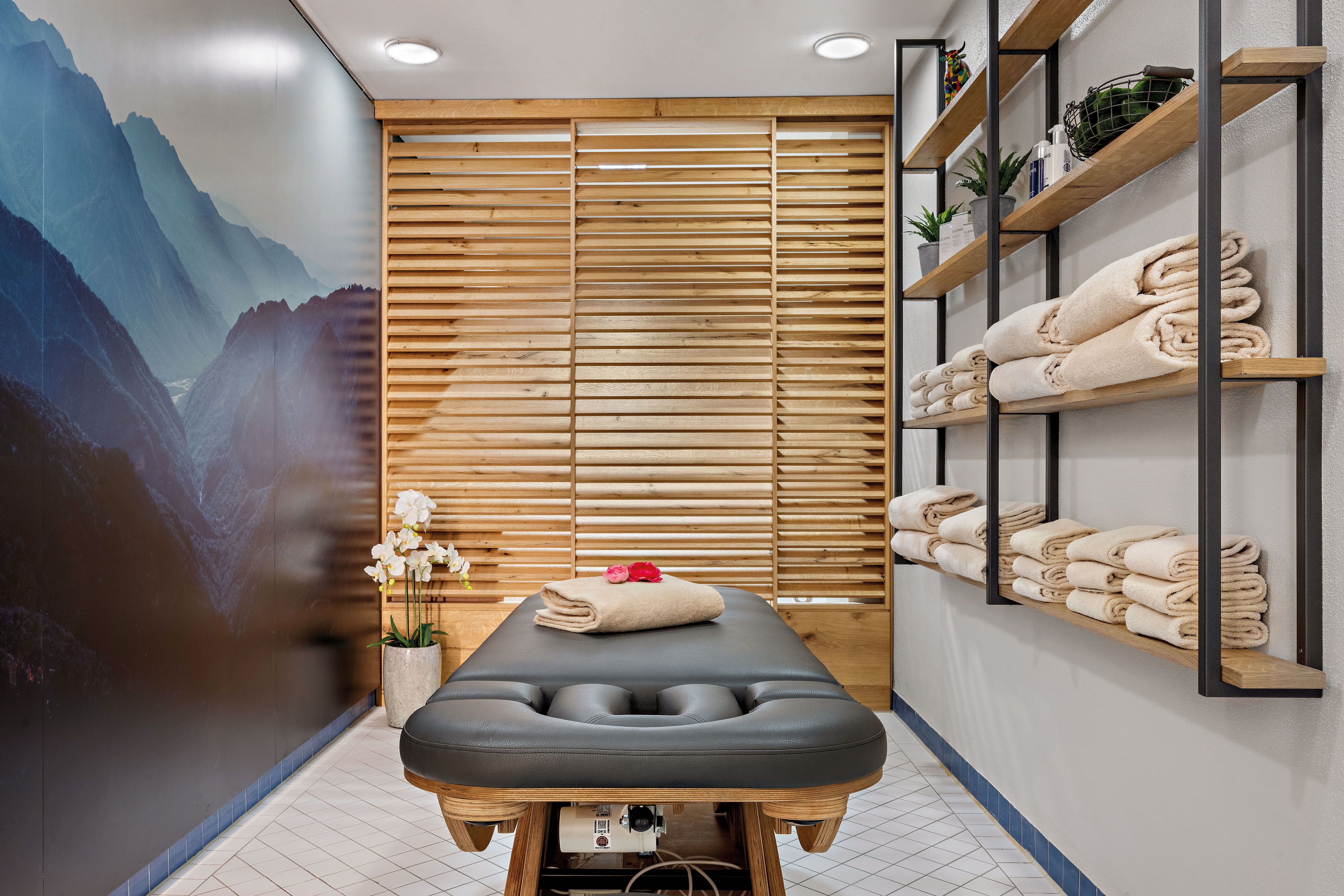 Massage Bed and Folded Towels in Treatment Room at the Spa