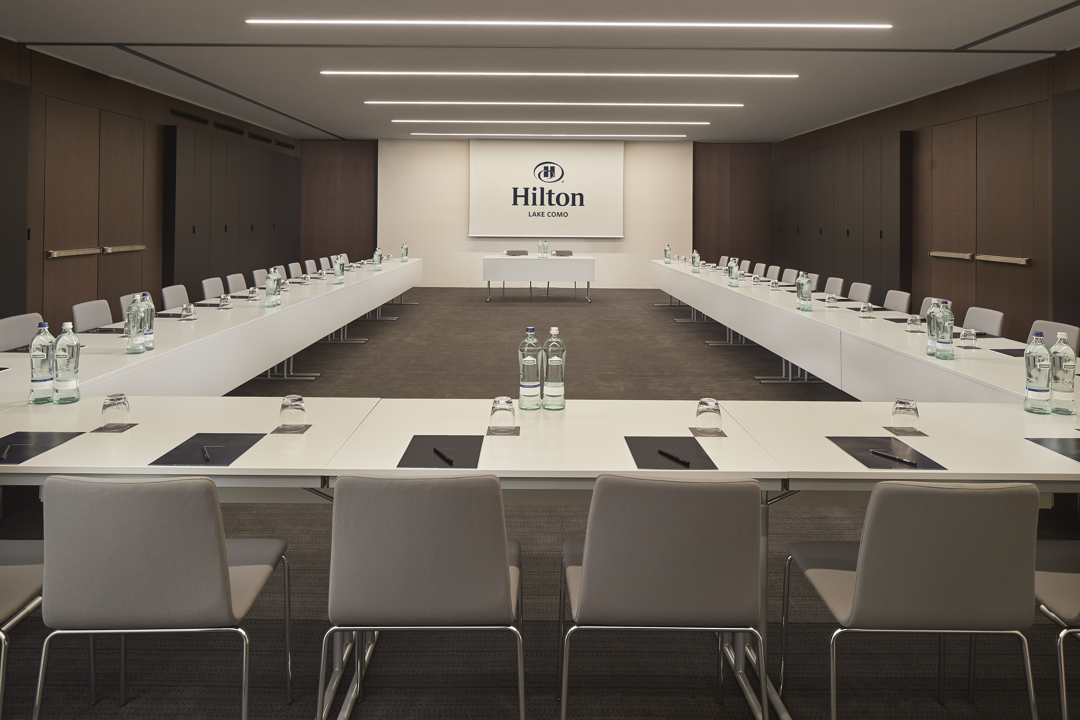 Sala meeting con tavolo a forma di U e schermo multimediale