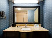 Standard bathroom vanity mirror, sink, and bathroom amenities
