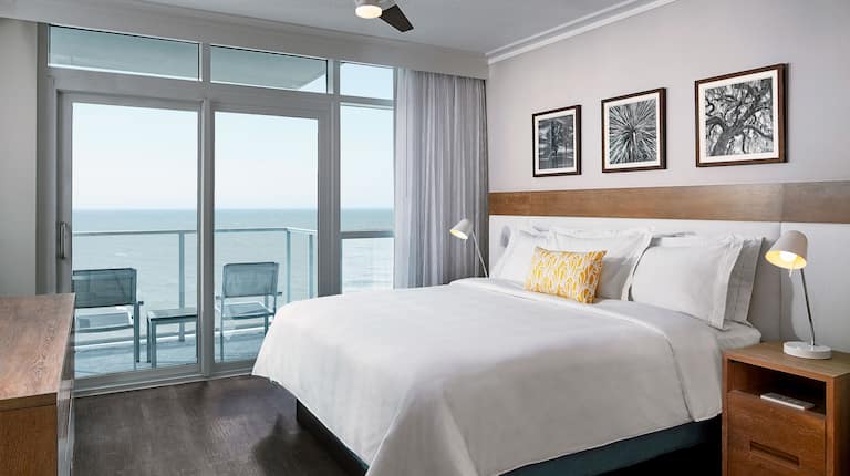 房间内的床,墙上有艺术品,外面有椅子