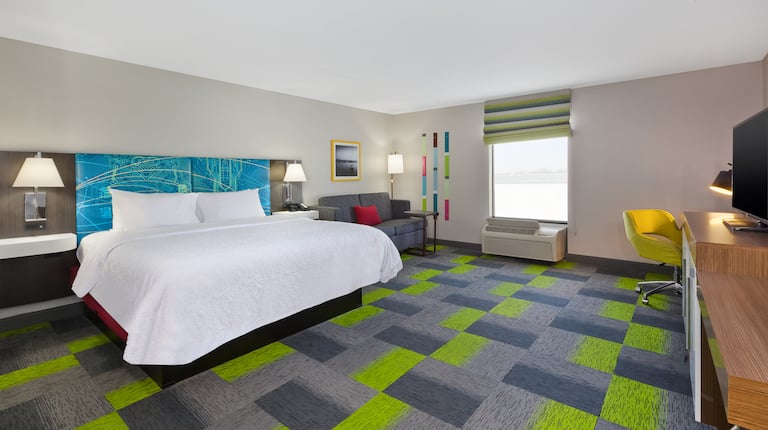 Spacious king room with bed and tv