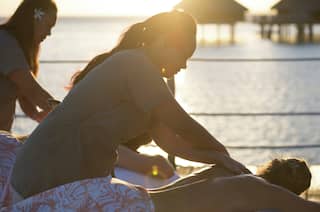 Les clients profitent d'un massage à l'extérieur au coucher du soleil