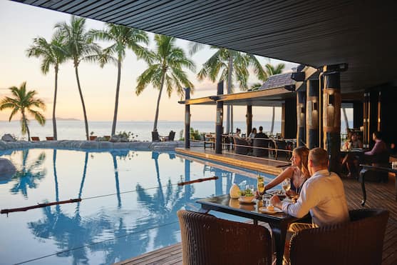 Guests Dining Poolside at Vulani Restaurant With Sunset View