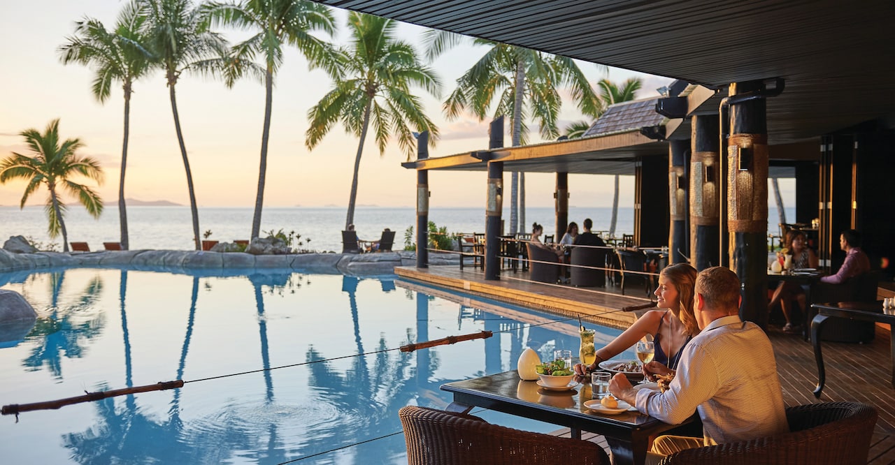 Guests Dining Poolside at Vulani Restaurant With Sunset View