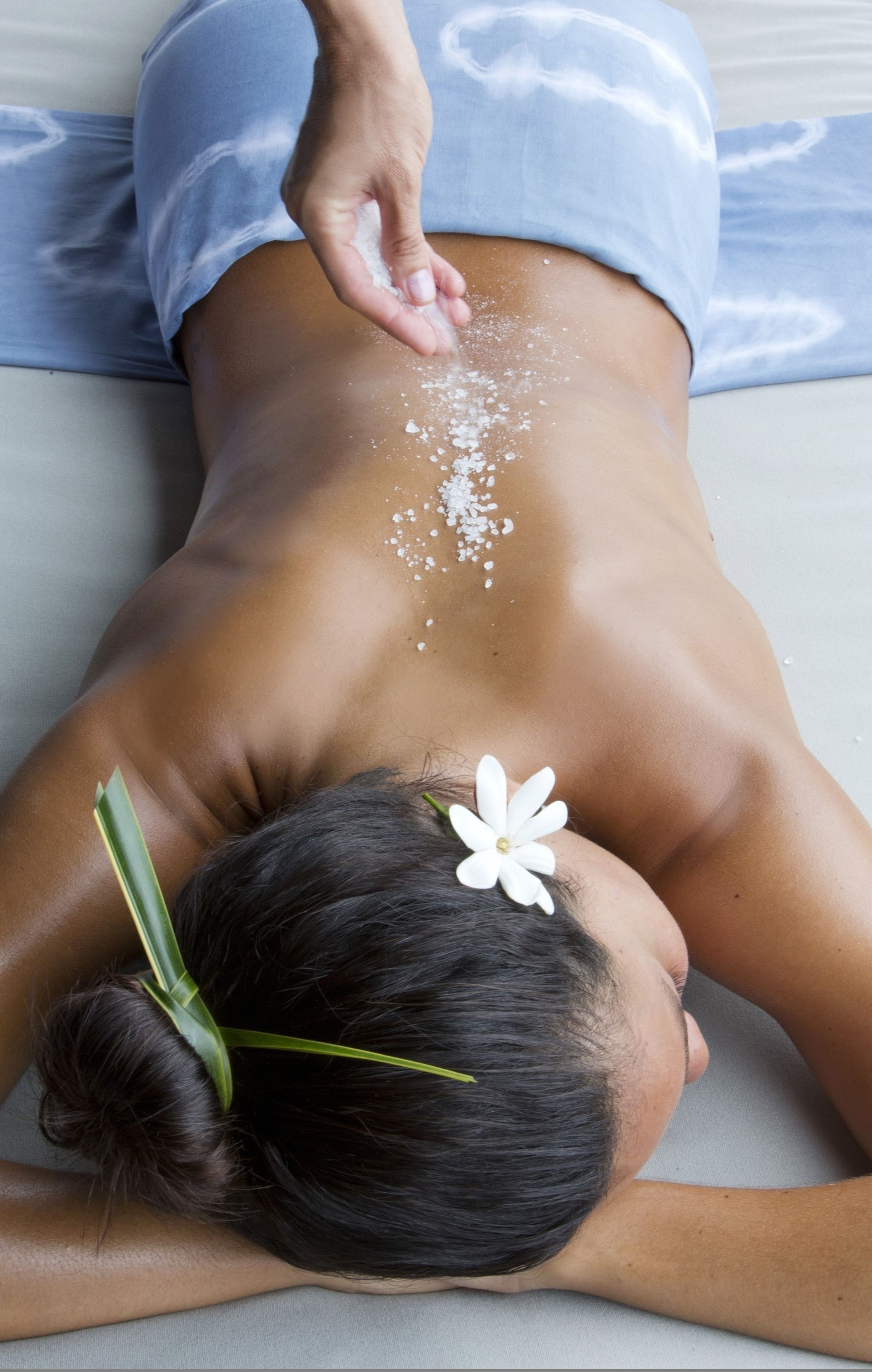 Woman at a spa laying down while getting scrub treatment 