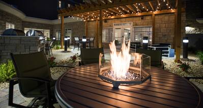 Close-up of outdoor patio firepit, surrounded by chairs