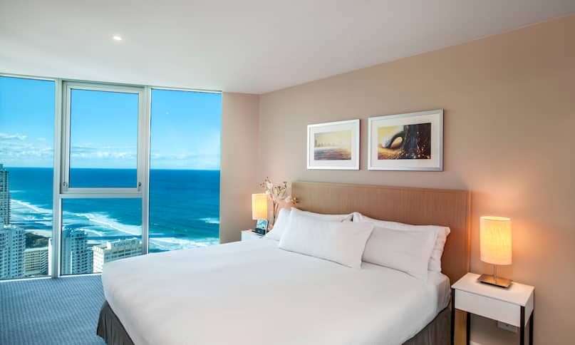   Bed in Guest Room with Large Window Overlooking Ocean -next-transition